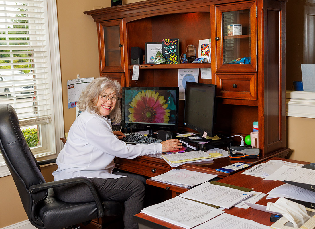 Report a Claim - Debra Campana Siss Working at Her Desk